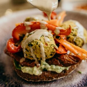 A delicious vegan falafel burger with fresh vegetables and tahini sauce, perfect for a healthy meal.